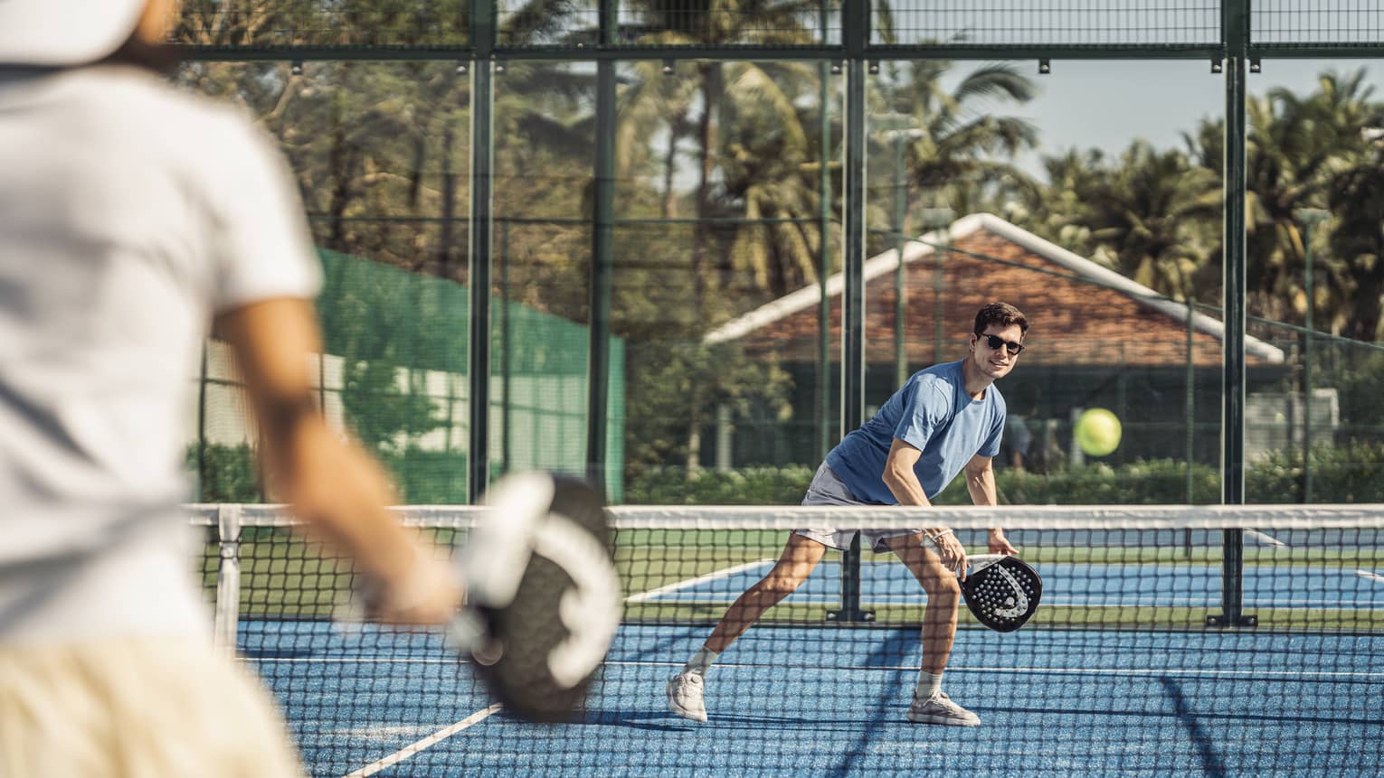 Couple plays paddleball on artificial turf court