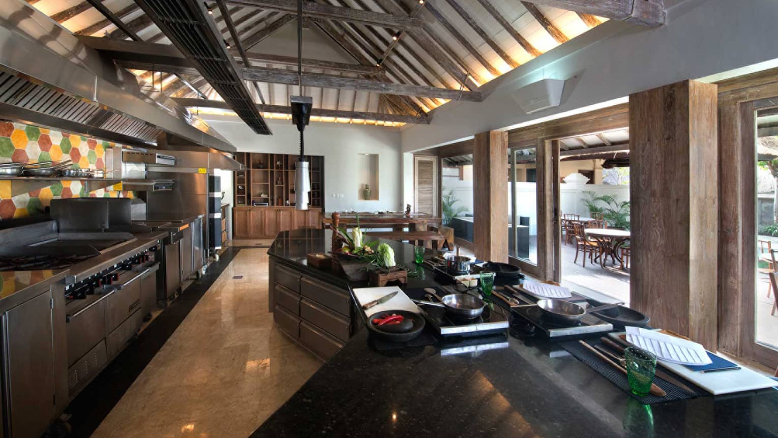 Jimbaran Bay Cooking Academy kitchen with stainless steel appliances, black marble counters, large windows
