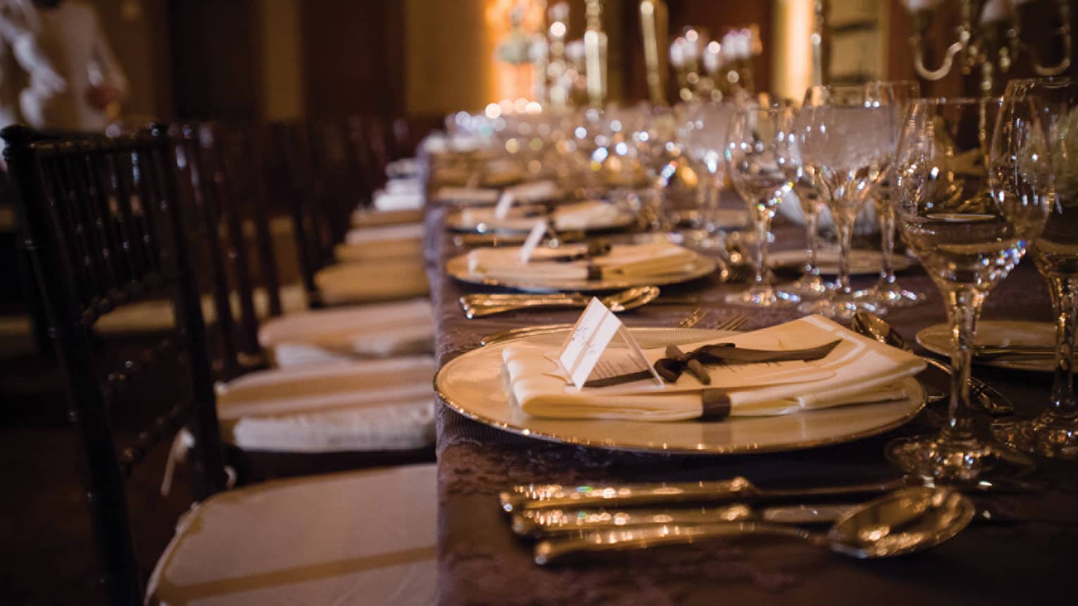Wedding reception table setting, name cards and linen napkins on plates
