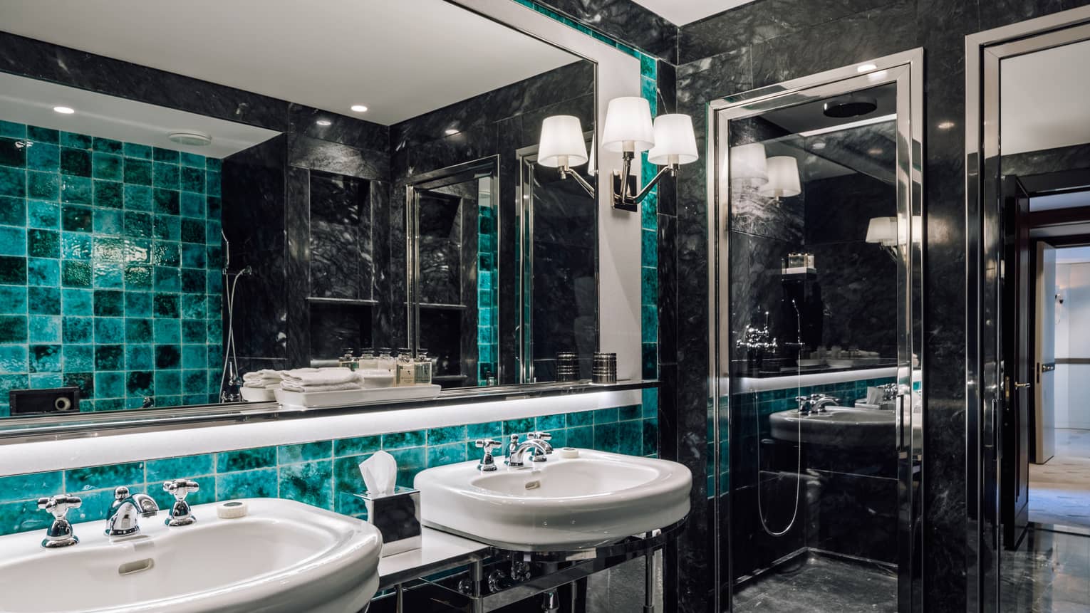 Black marble bathroom with turquoise accent tiles, two sinks, full-width mirror