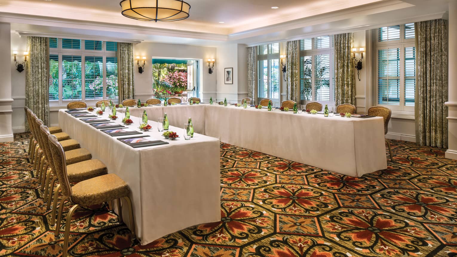 El Jardin carpeted meeting room with modular tables set with water bottles, fresh grapes