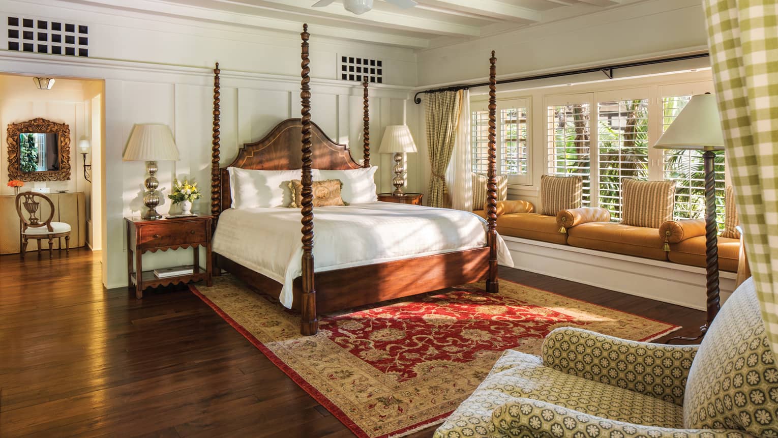Poster bed in sunny Ty Warner bungalow bedroom, built-in cushioned bench under long window