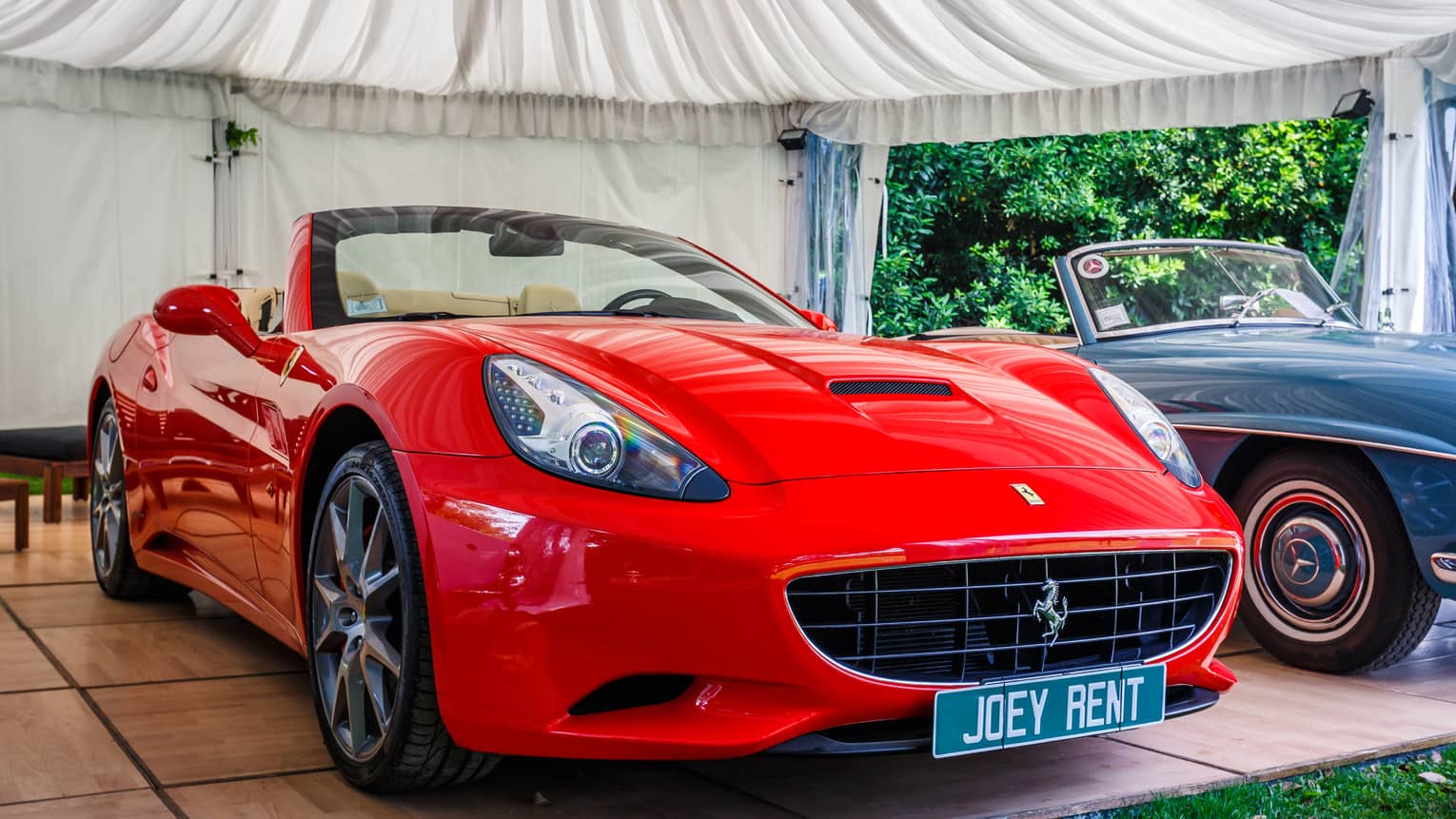 Bright red Ferrari sports car with licence plate Joey Rent 