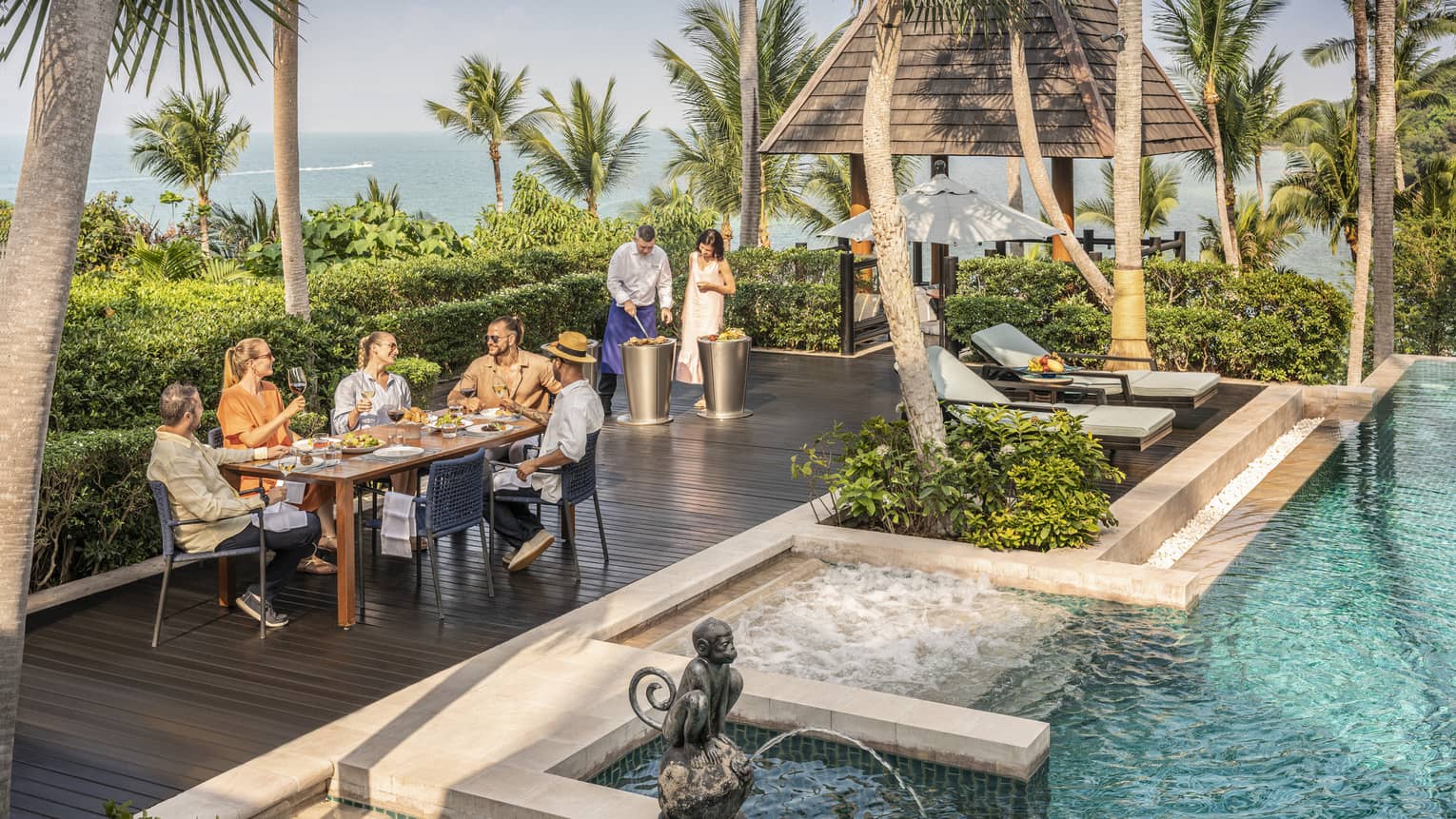 Group of friends enjoys a poolside barbecue lunch