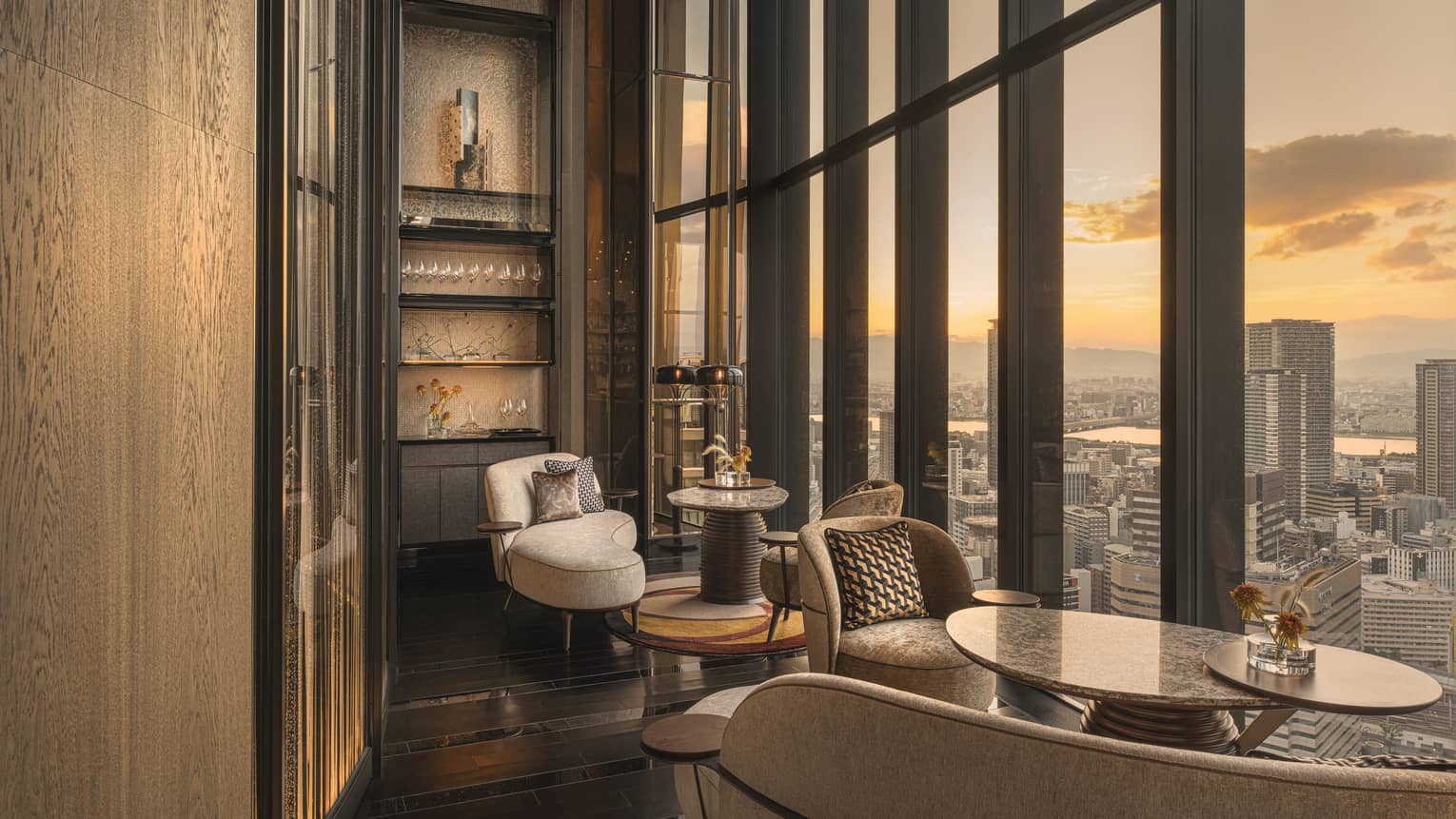 Four Seasons Hotel Osaka bar seating set next to wall of windows overlooking city