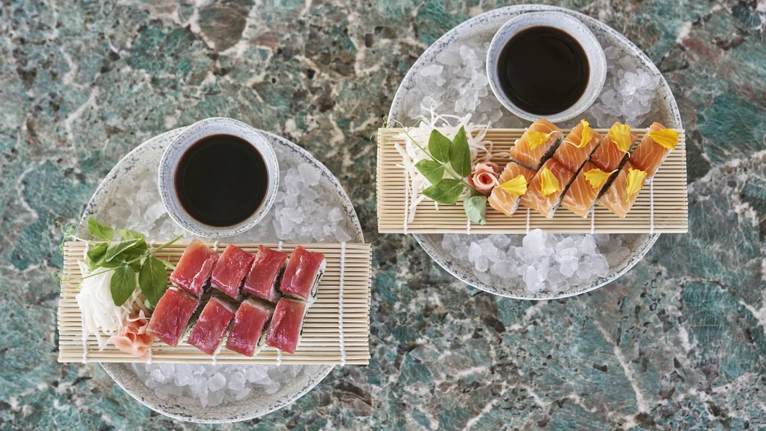 Two plates of sushi resting over ice.