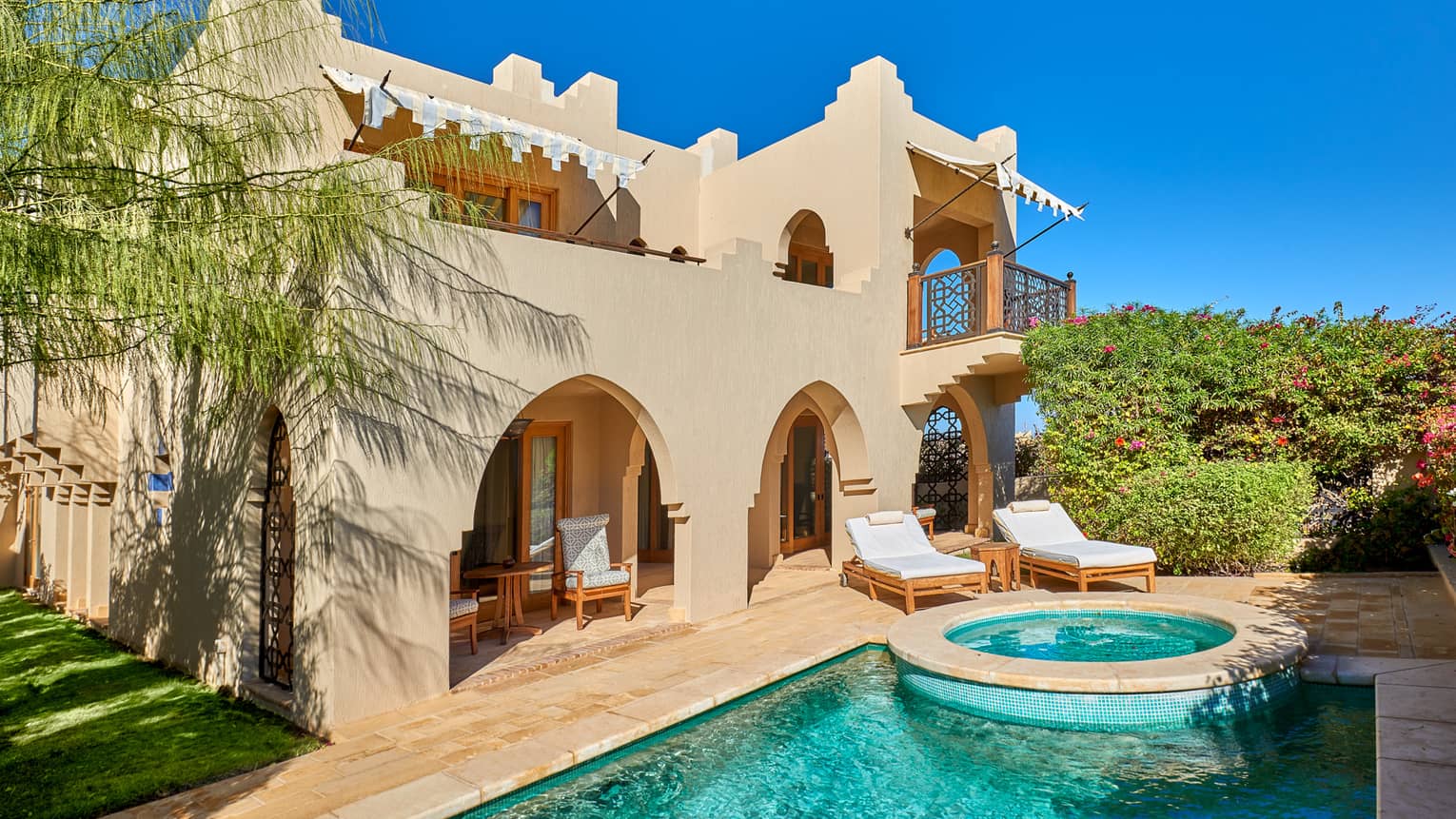Exterior view of four bedroom villa and private pool against blue sky
