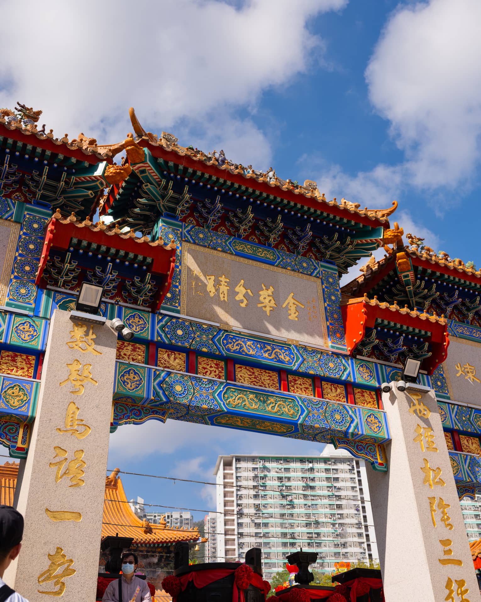 Ornate entrance to a temple in Hong Kong, Wong Tai Sin, with blue and red colours and gold writing