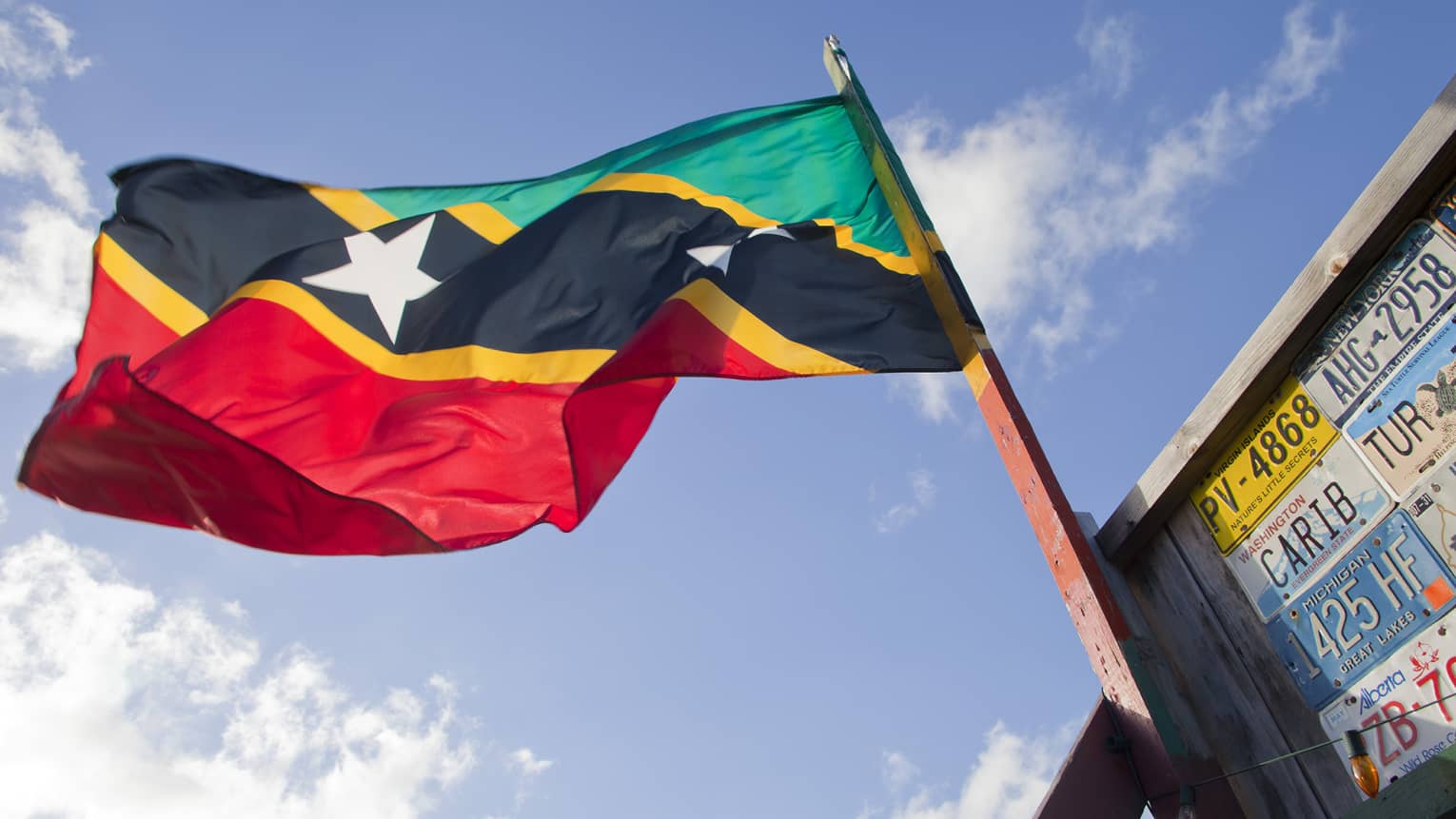 Flag waving in the wind with the sky in the background.