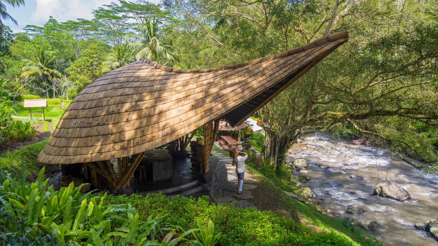 Small building with modern, extended roof overhang, next to river in Bali