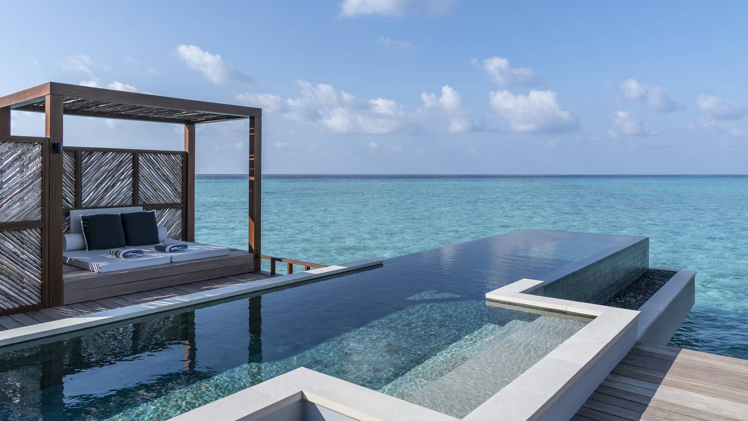An oceanside infinity pool with a covered cabana 