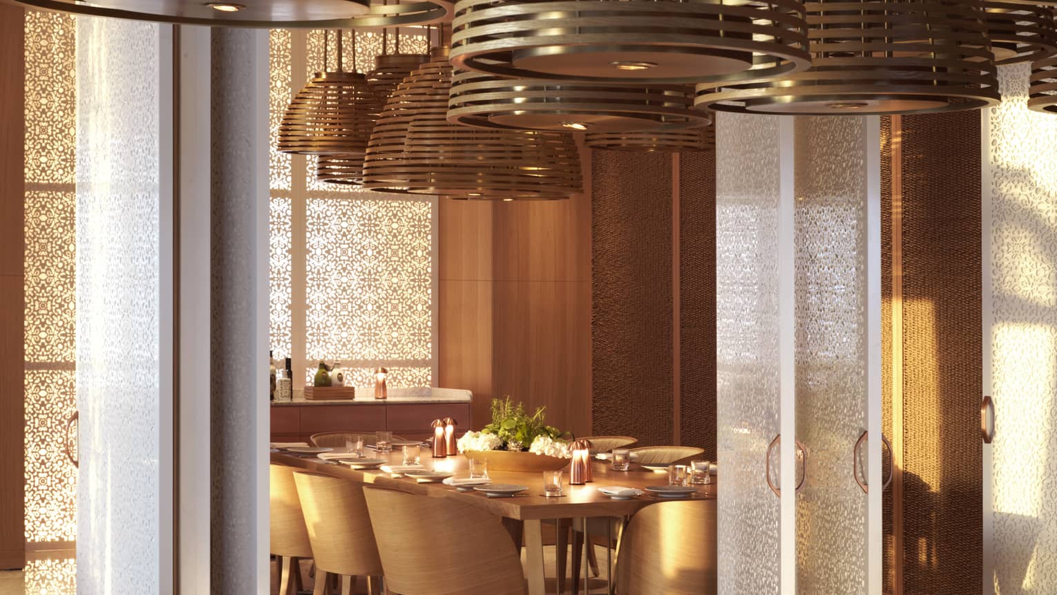 Large overhead lamps hang over a long mahogany table.