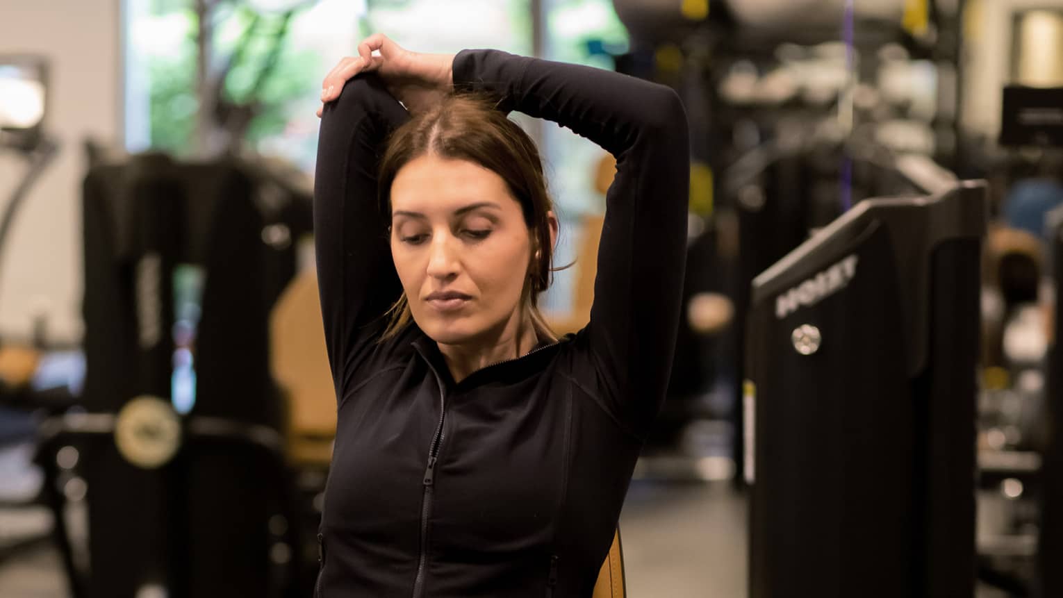 Guest stretching while sitting on an exercise machine.