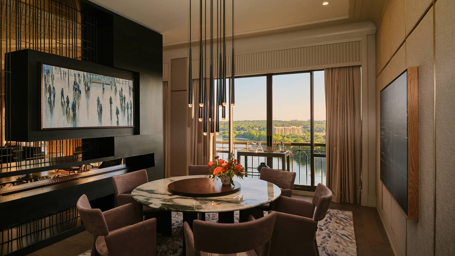 Hotel suite dining room featuring a round marble table with six chairs and a contemporary hanging light fixture