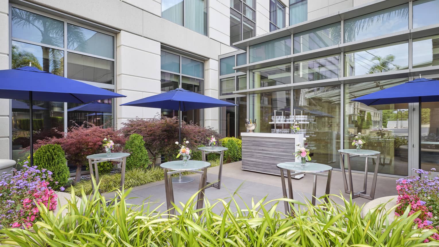 Outdoor dining patio with blue umbrellas with the tables.