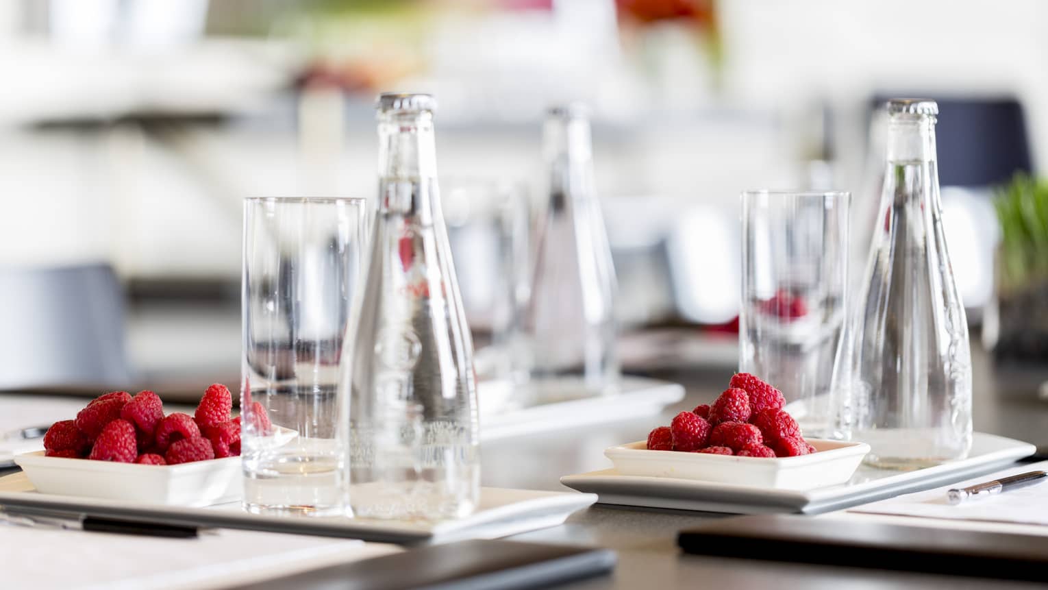 A detail from a meeting – clear glasses and red raspberries on a dark wooden table at Four Seasons Atlanta