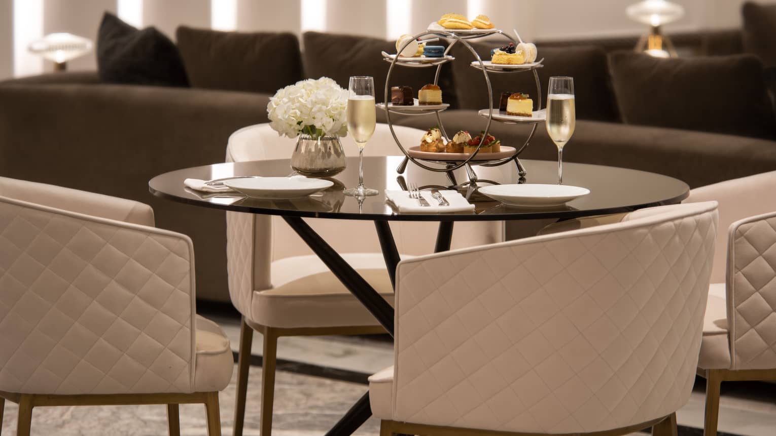 A small round table with an afternoon tea set on it.