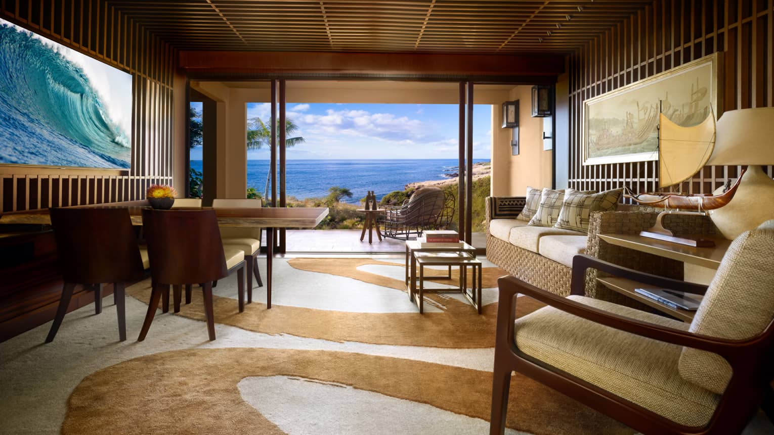 Teak panel wall with TV, wood dining table across from wicker sofa, swirl-patterned carpet