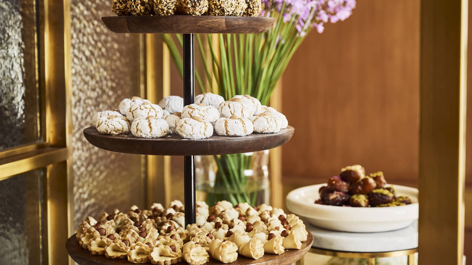 A three-tiered serving tray filled with various pastries