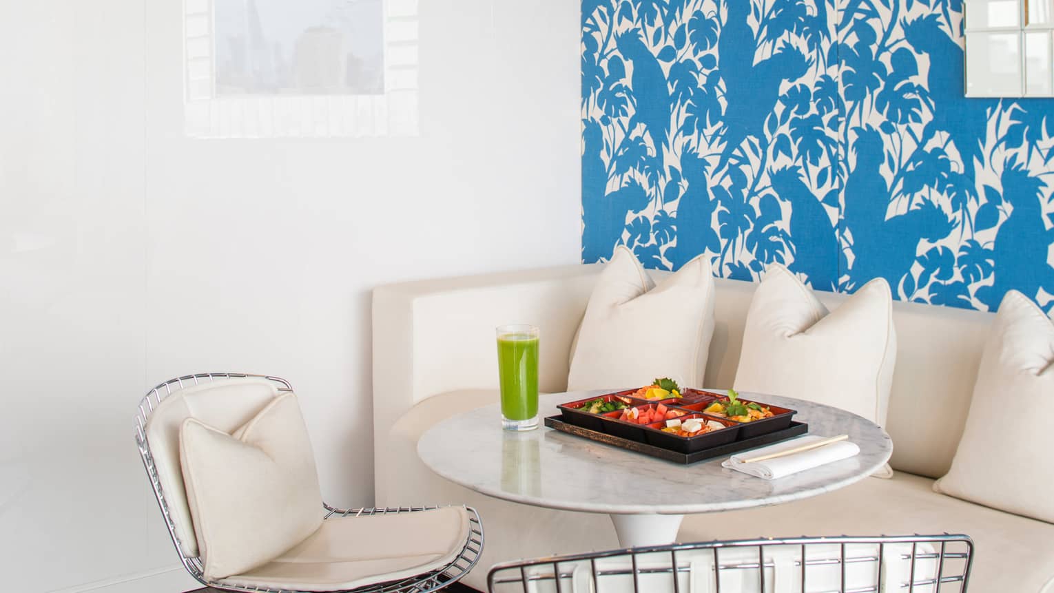 Small spa dining table with cheese, fruit in tray, glass with green smoothie