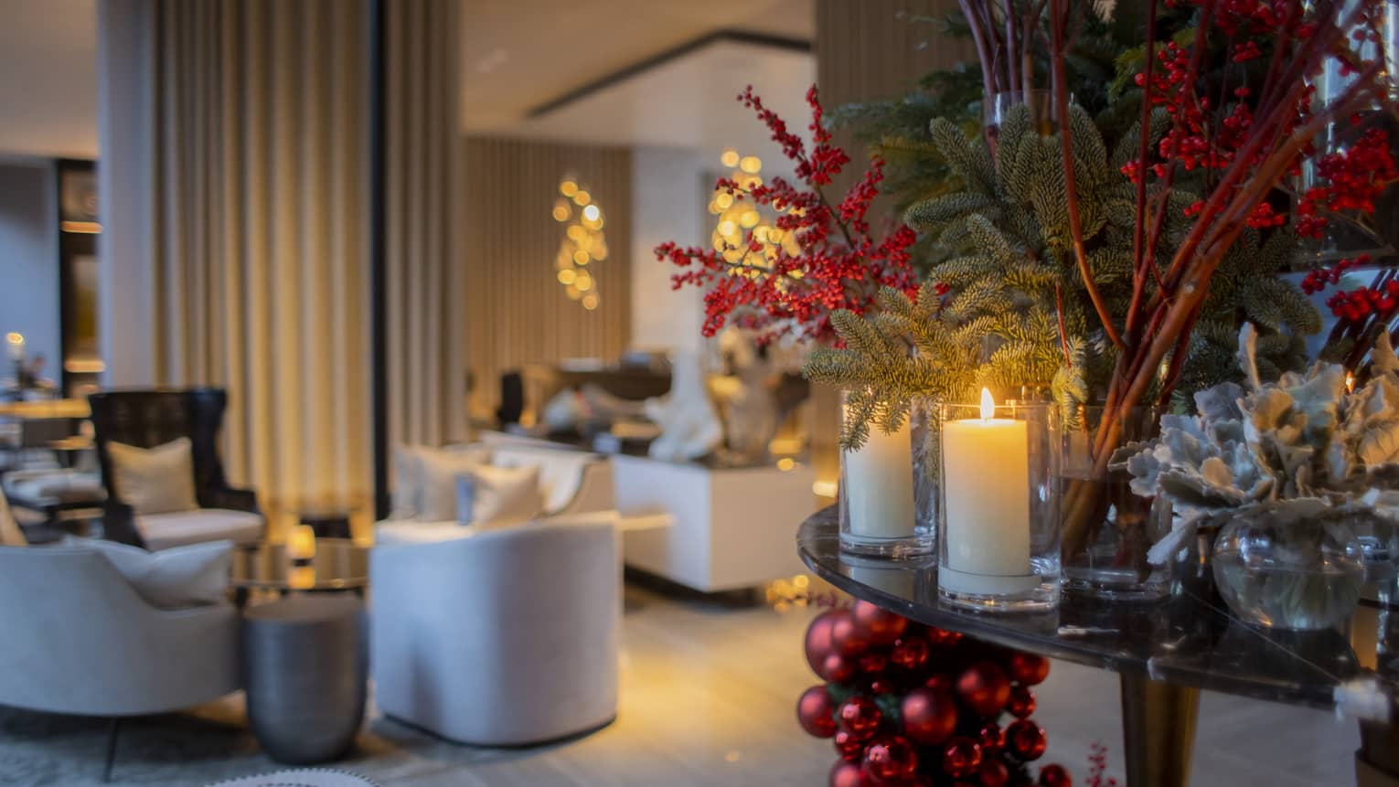 Dimly lit dining area at The Lounge decorated for Christmas with candles, holly and pine