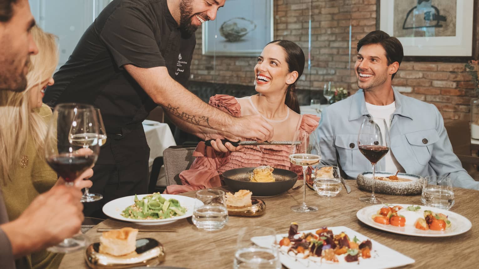 A group sitting around a round table eating food.