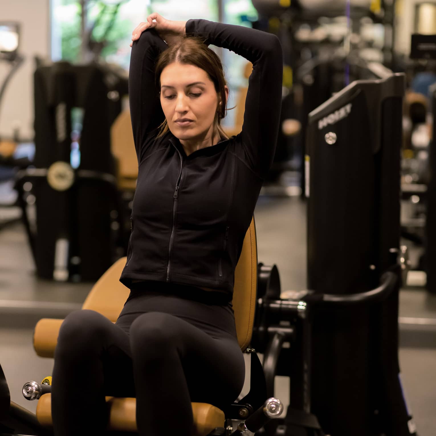 Guest stretching while sitting on an exercise machine.