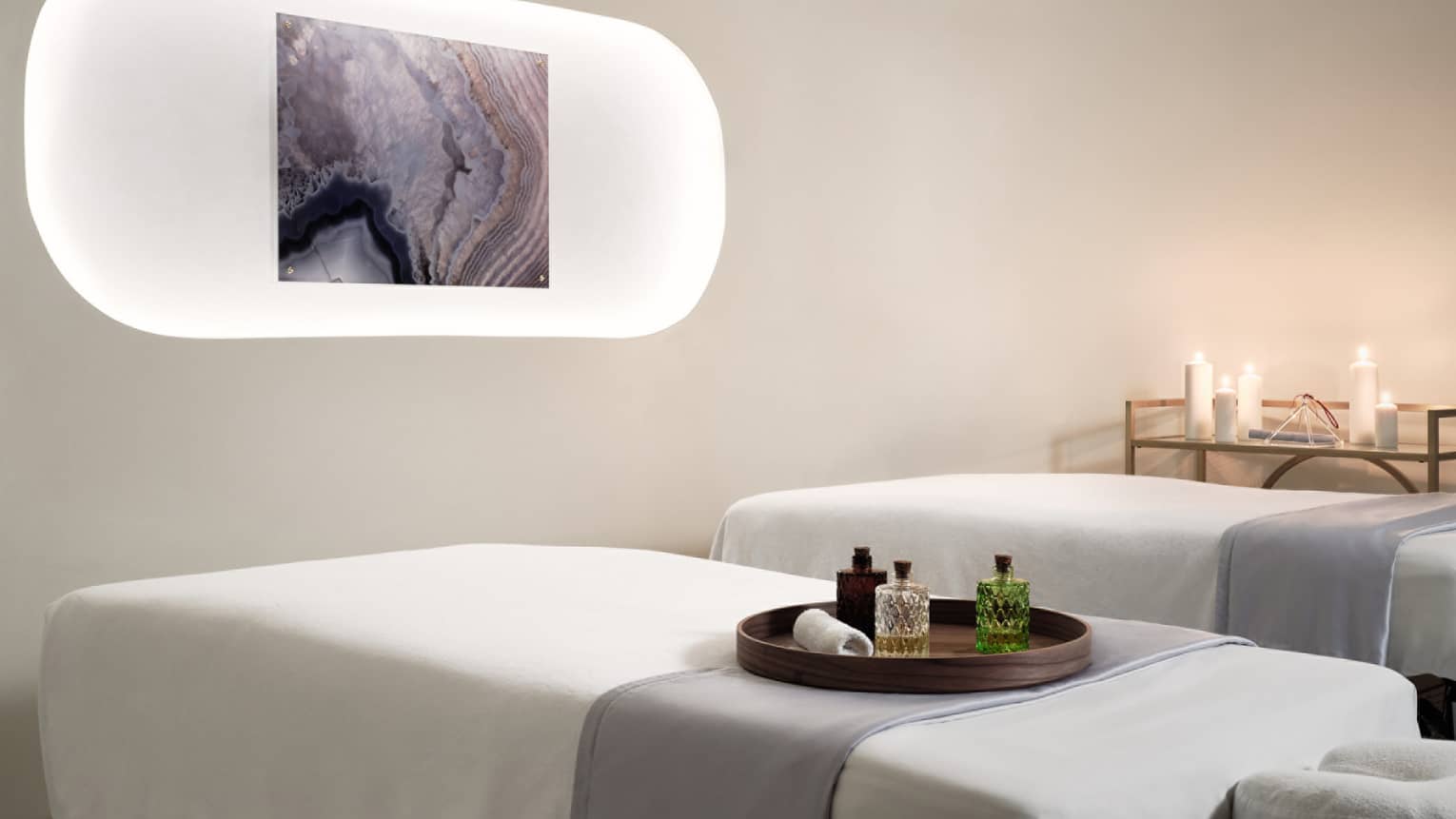 Massage tables with white sheets and candles.