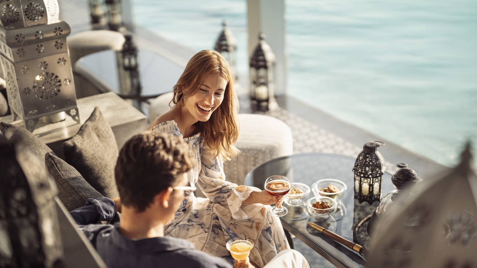 Smiling couple enjoys mezze poolside at Al Barakat