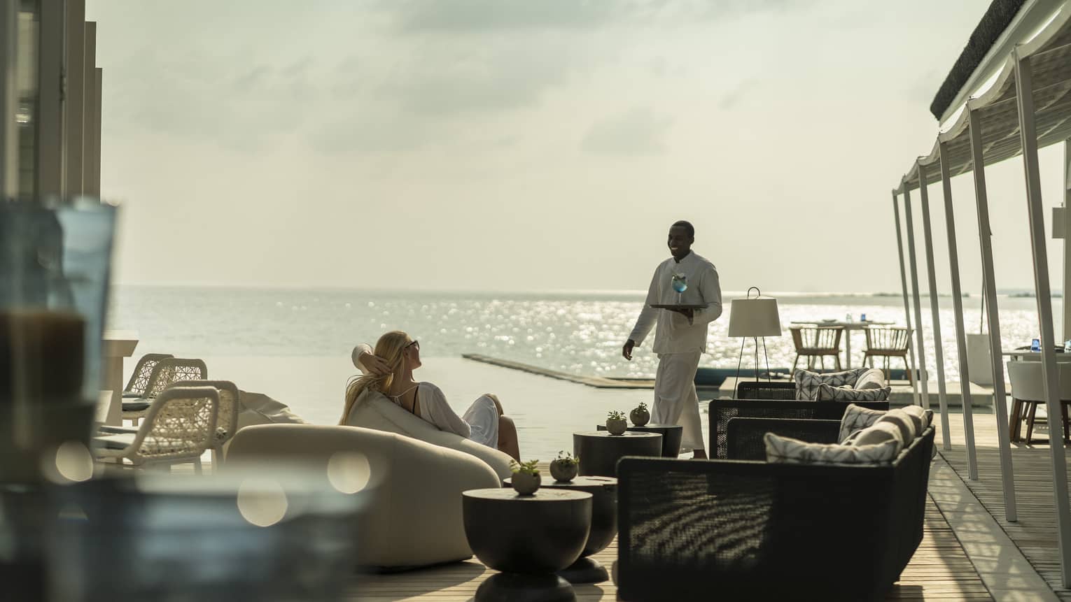 A guest receives a cocktail while relaxing outside at the Blu Beach Club