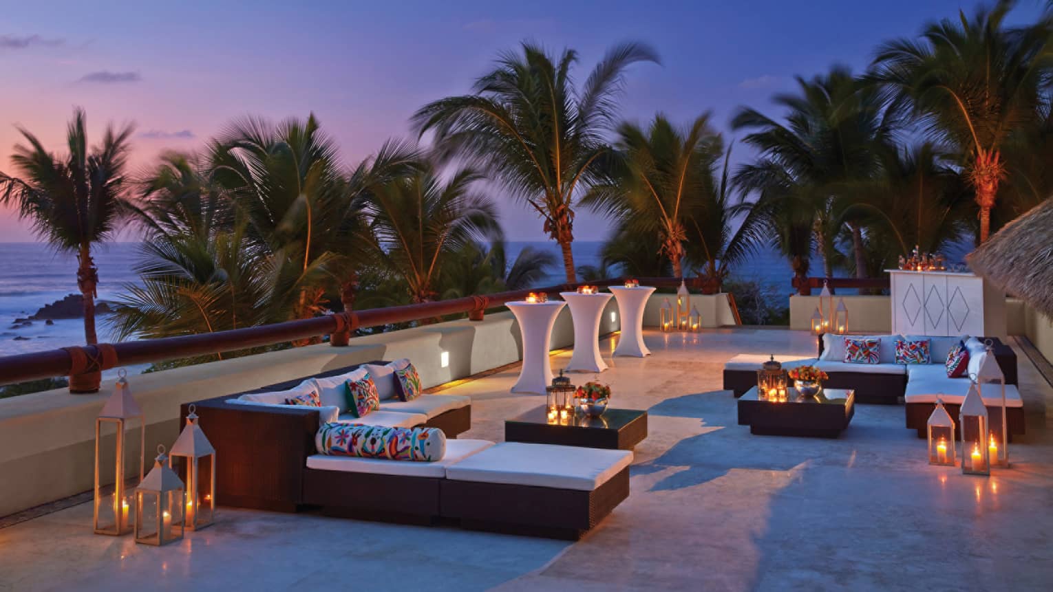 Trendy outdoor lounge at dusk, overlooking the beach
