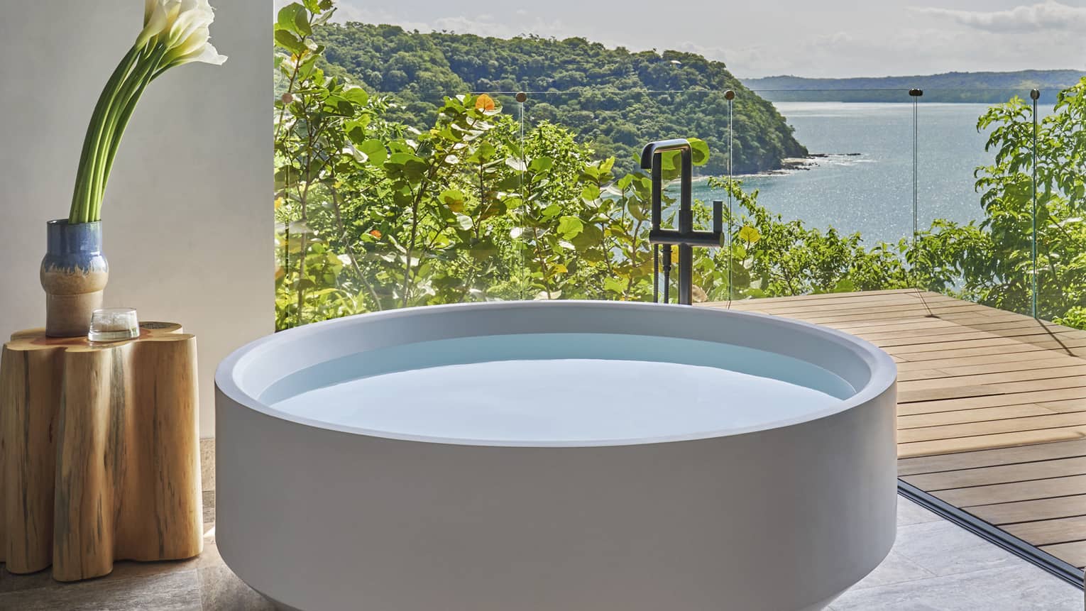 A stand-alone, circular tub on a private terrace overlooking the sea