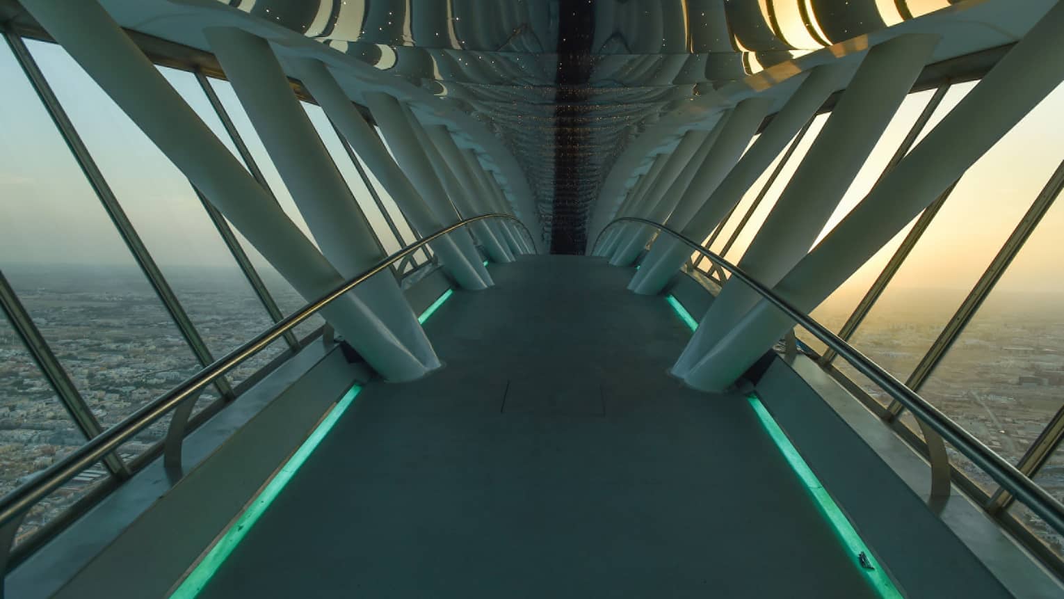 Looking down through white Sky Bridge, city far below