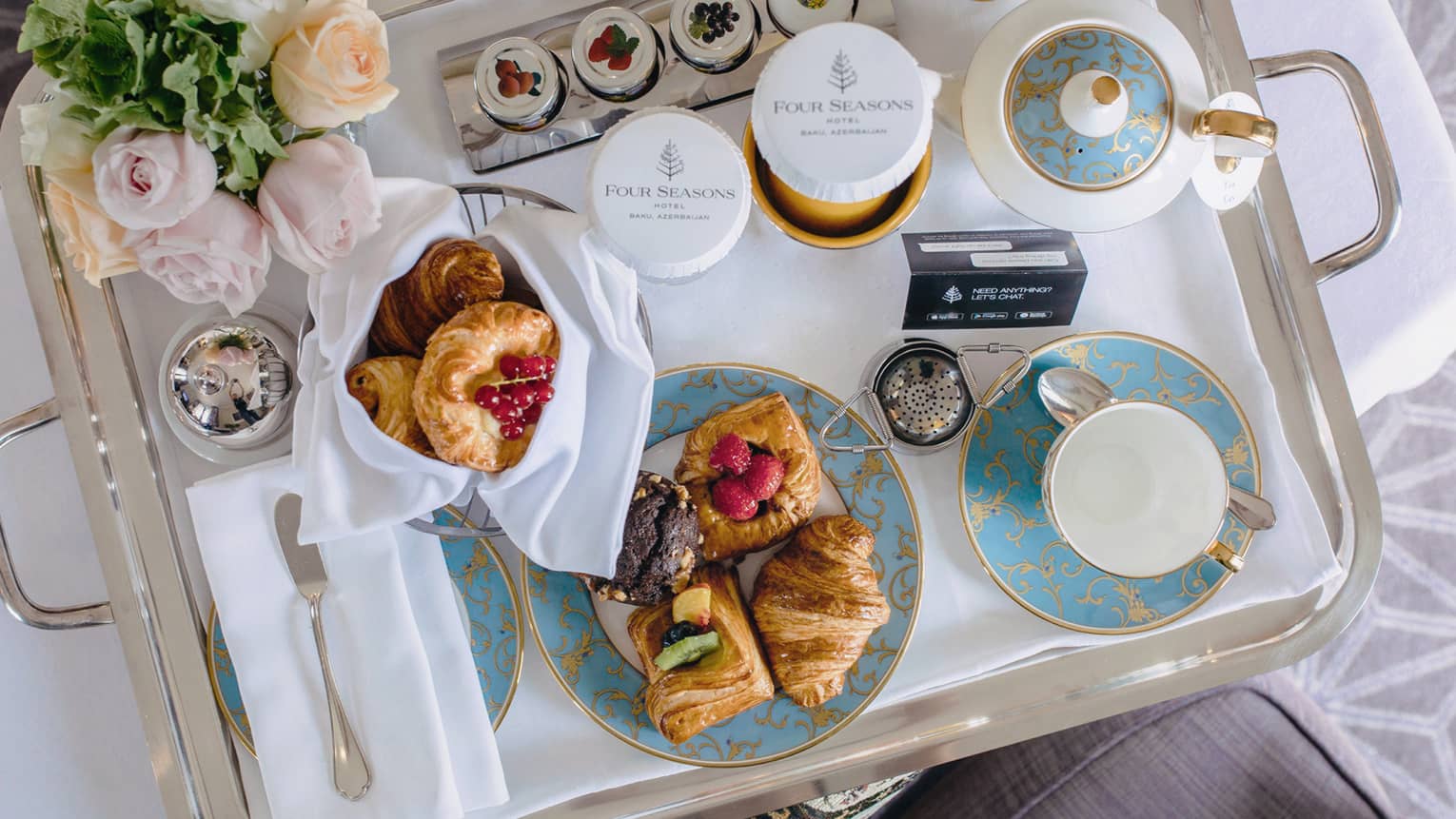 In-room dining breakfast tray with tea, pastries, roses