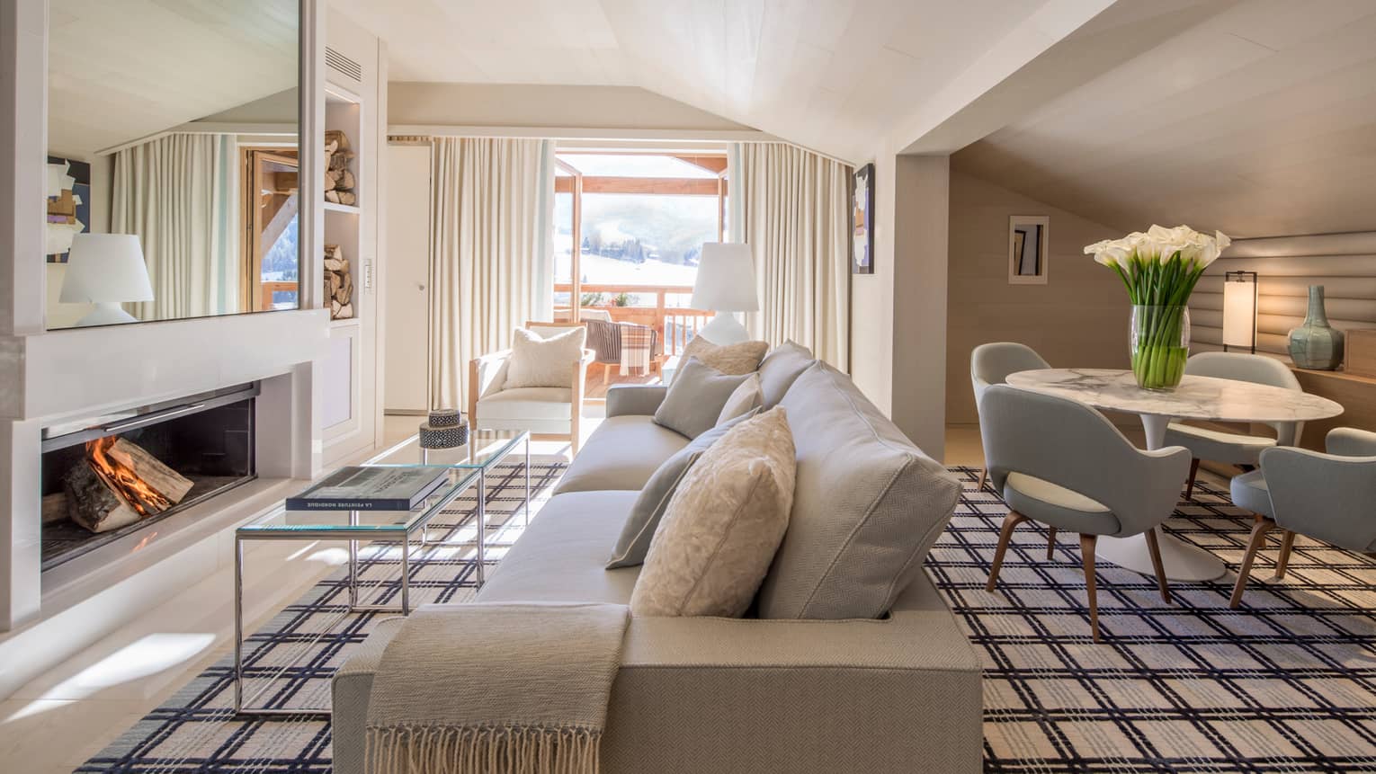 Suite Rochebrune white sofa, armchairs, glass table by modern fireplace, dining table