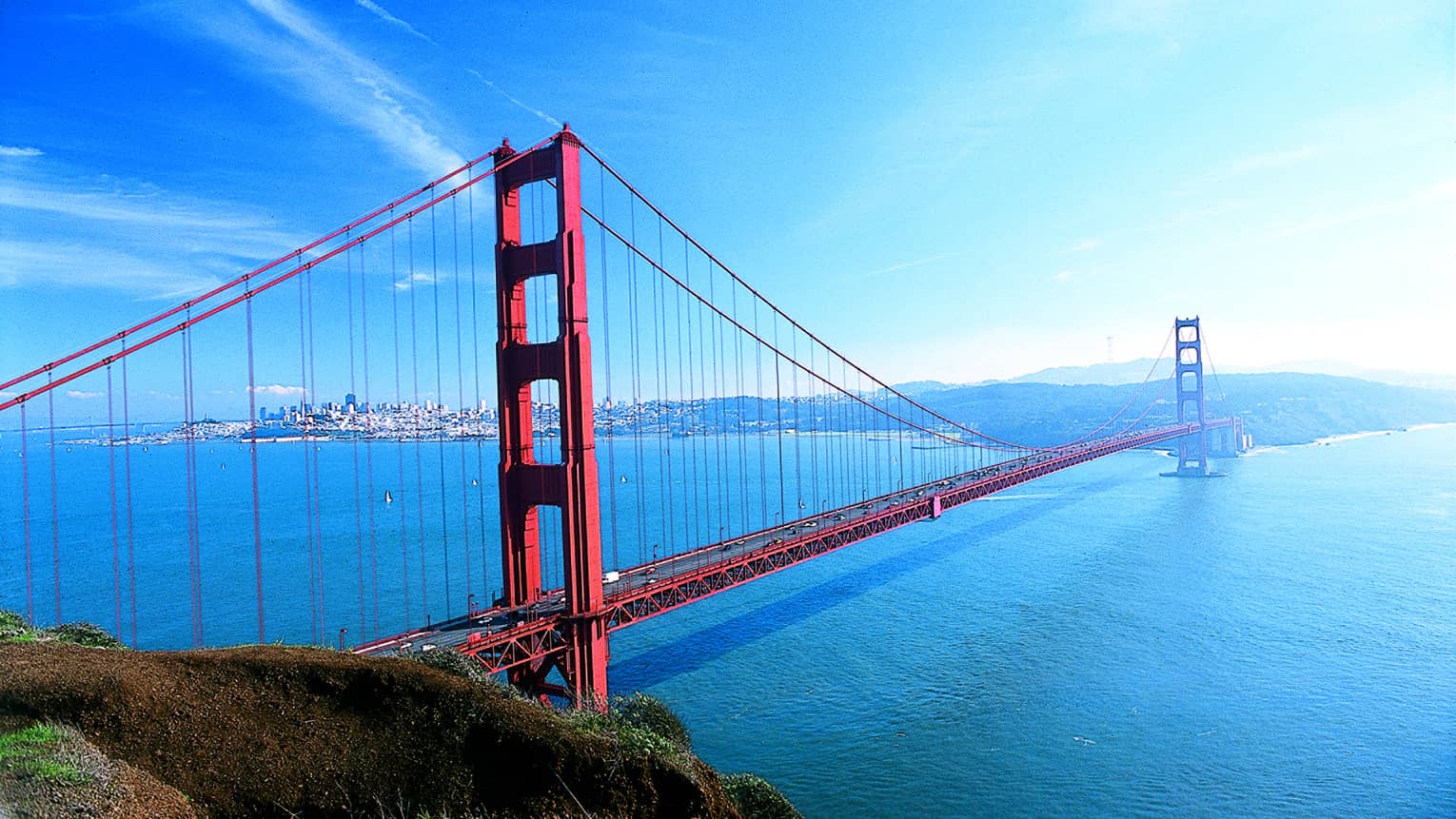 A large red metal bridge crossing water.