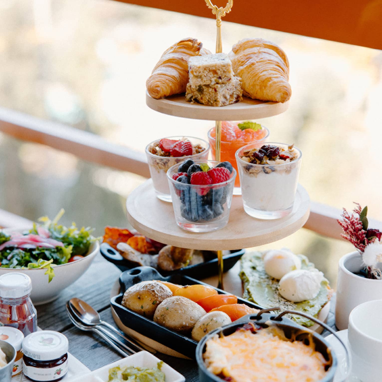 Three-tier tower with breakfast spread on outdoor table