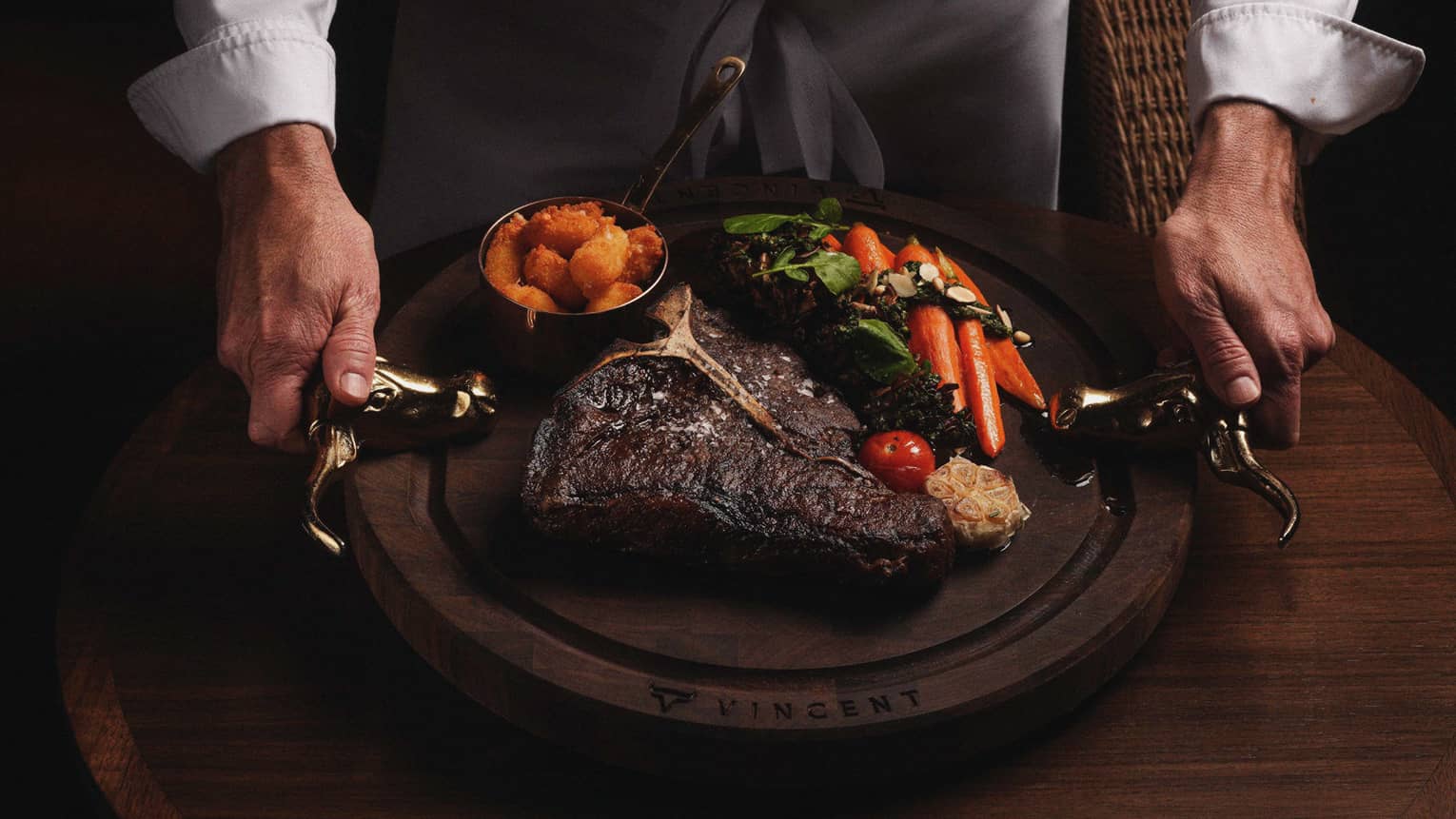 A large grilled steak on a plate with vegetables