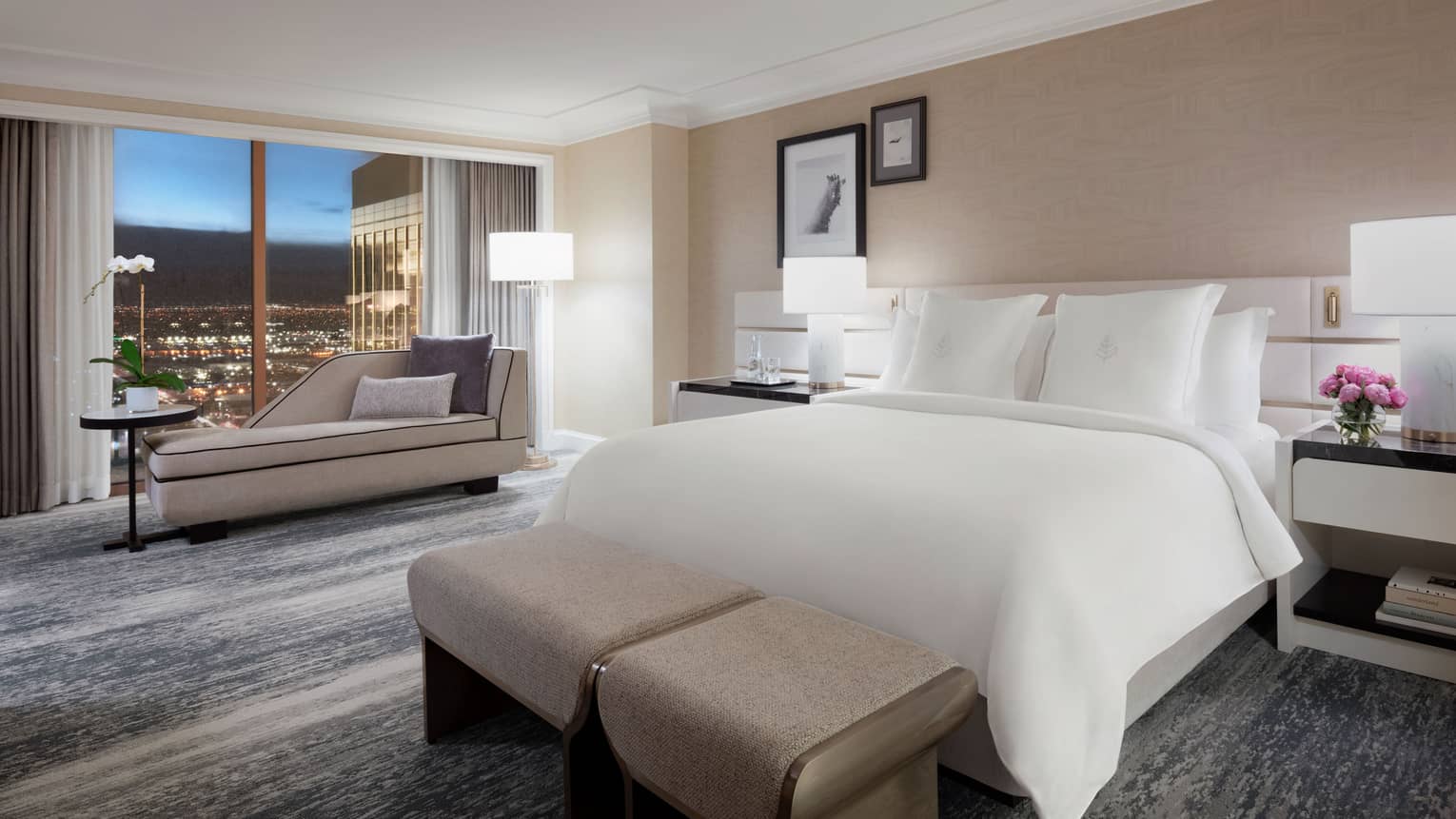 Modern bedroom with king bed and windowside chaise at Four Seasons Hotel Las Vegas