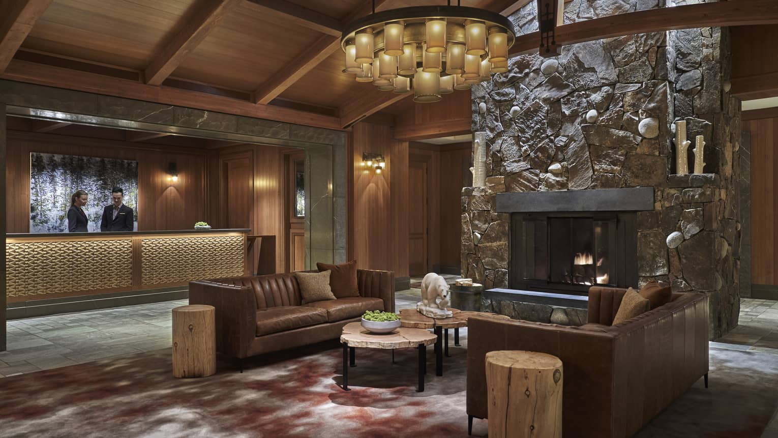 The lobby paneled with dark wood, with a couch in the centre of the room.