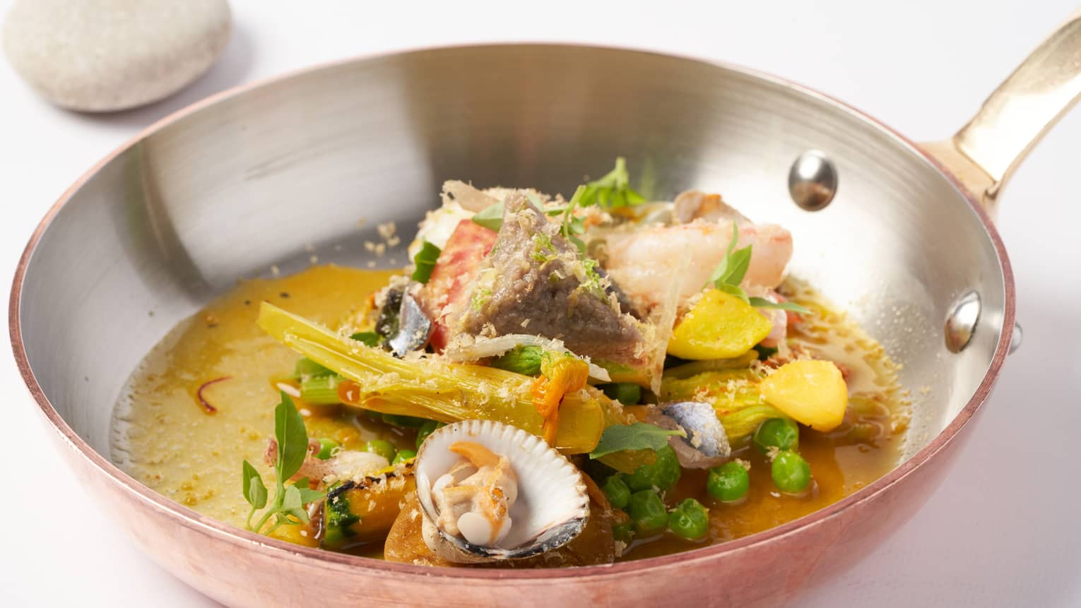 Pan-roasted Mediterranean seafood soup with clams, anchovies and vegetables from the hinterland