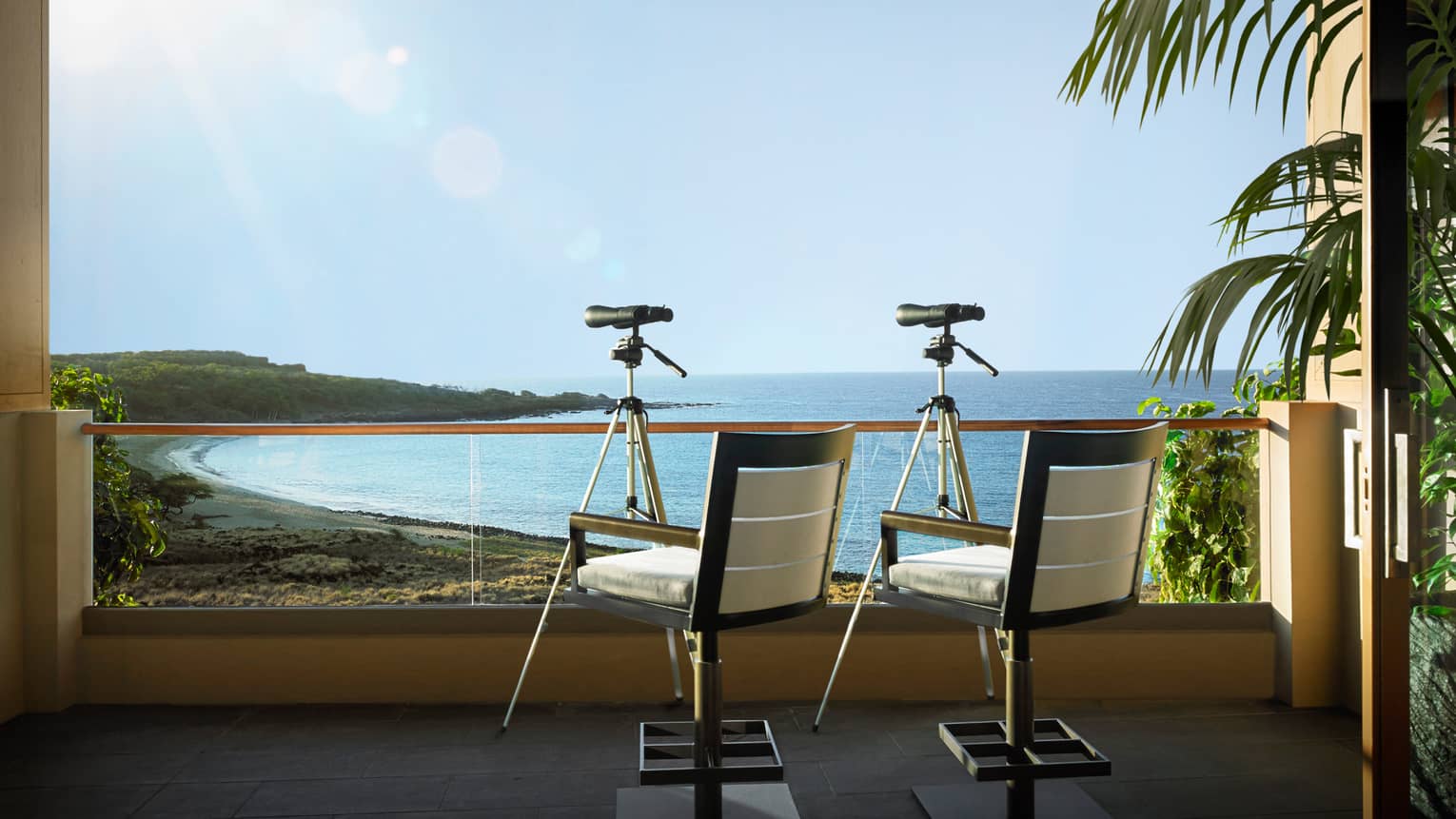 Two chairs and telescopes on a private balcony, overlooking Hawaiian beach