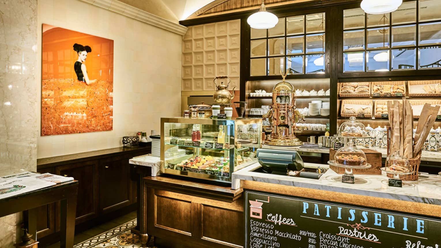 KOLLÁZS Brasserie & Bar Patisserie counter with pastries, bread in display case, large orange painting
