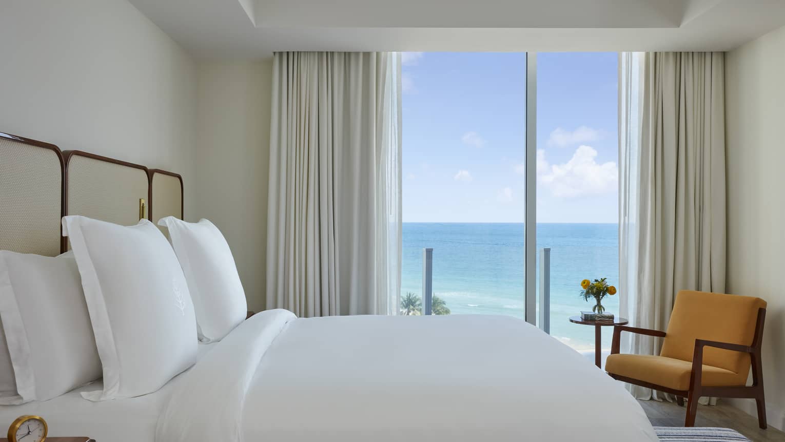 Bedroom with king bed, chair and ocean-view balcony