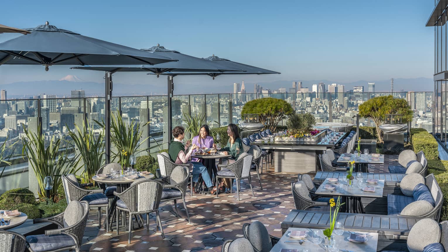 Group of three friends enjoy a meal on PIGNETO's open-air terrace
