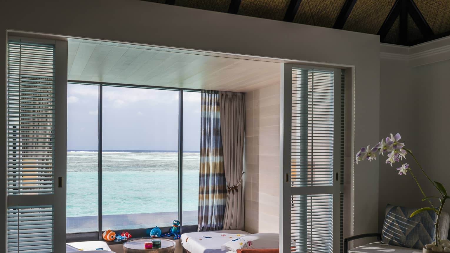 A kids' bedroom in a family villa overlooking a calm ocean