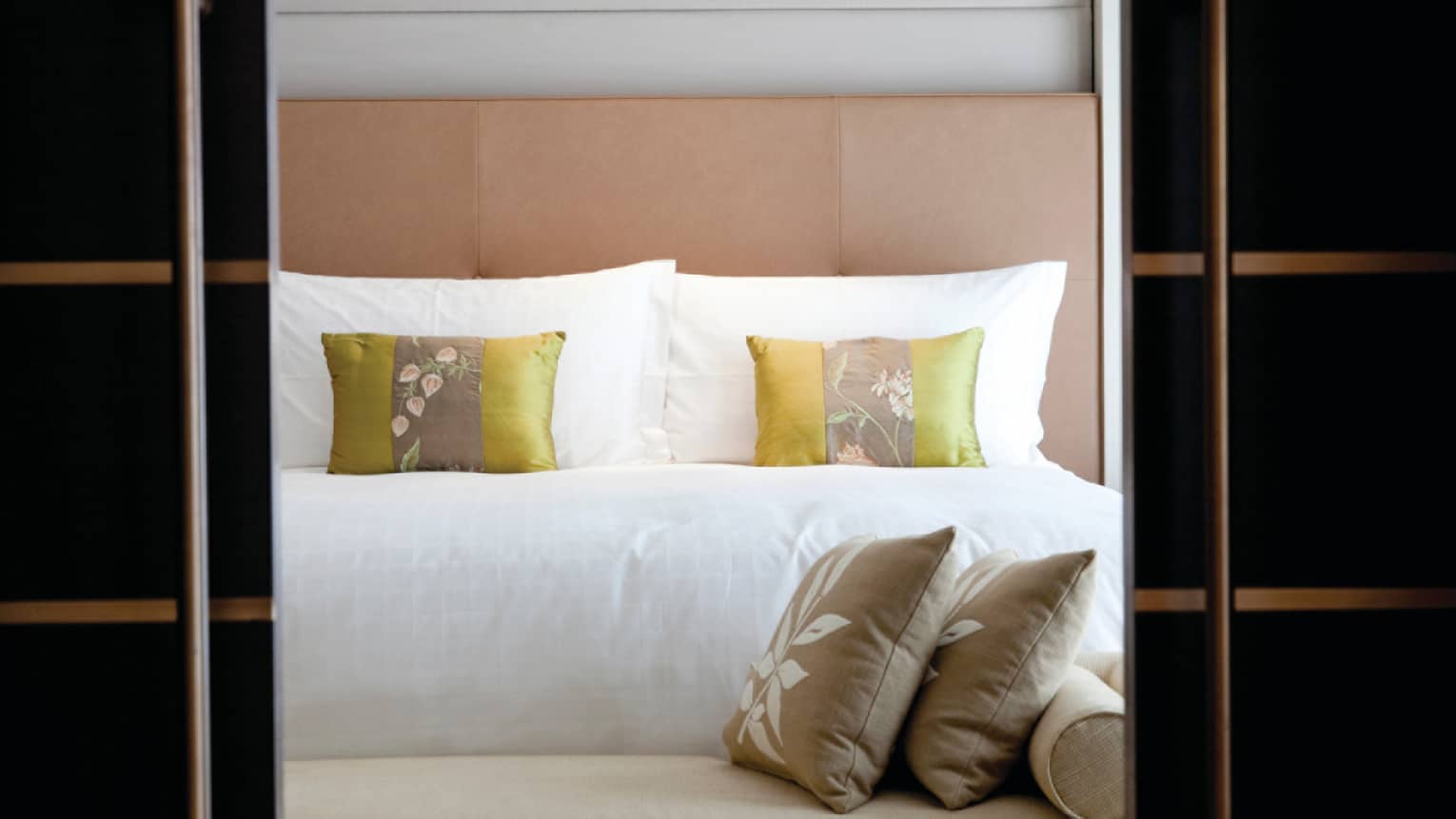 Garden-View Terrace Suite close-up of bench, accent pillows at foot of bed, padded headboard