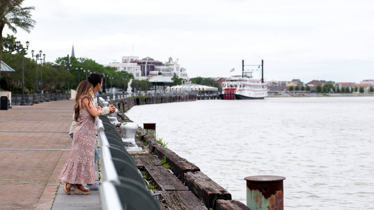 A woman and man looking out a river.