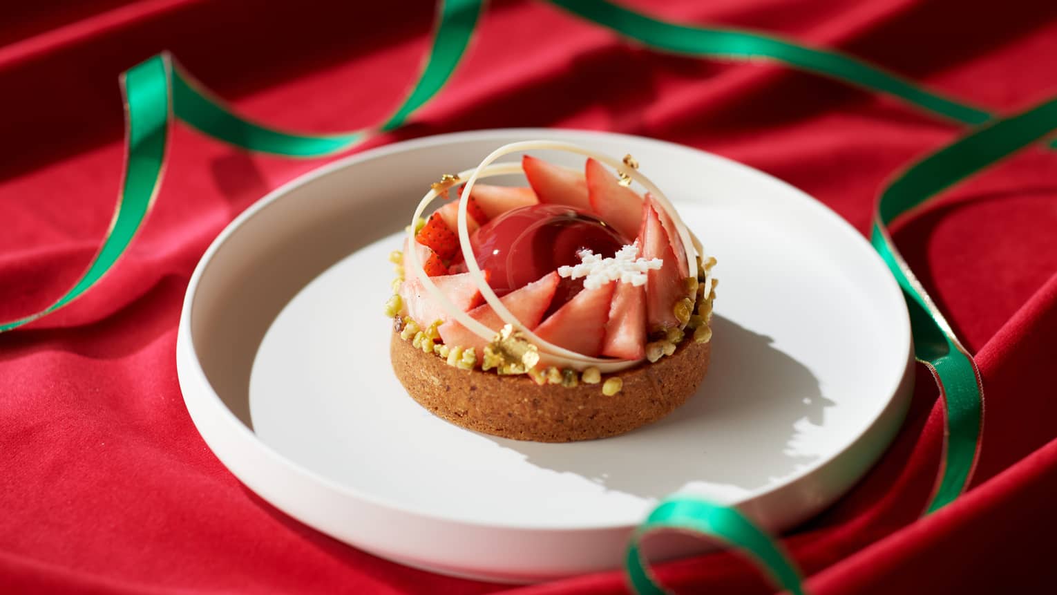 A tart with strawberries on a white plate.
