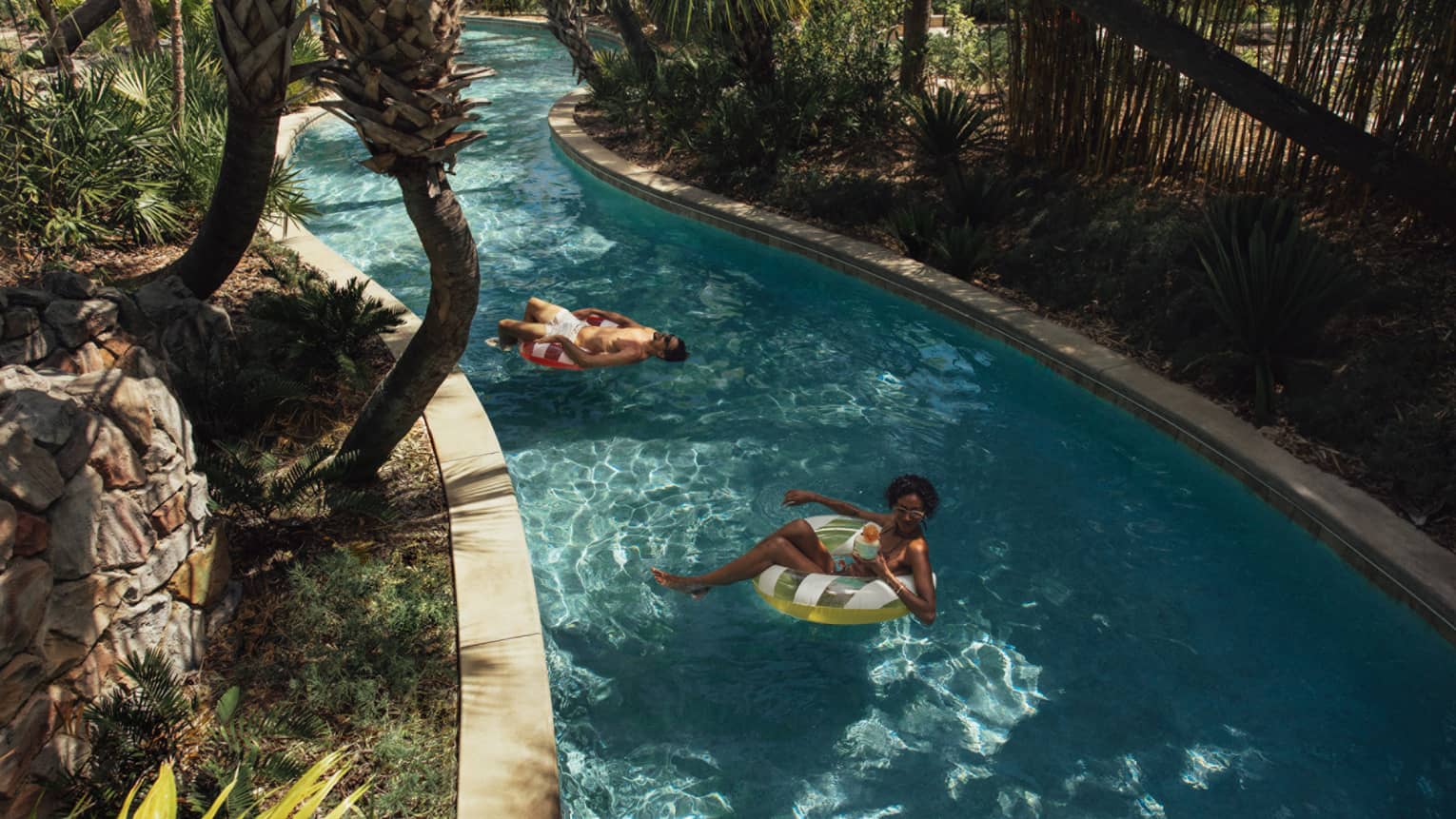 Two guests on floats on the lazy river.